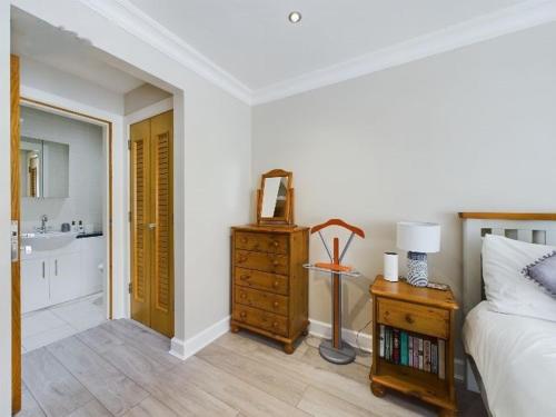 a bedroom with a bed and a bathroom with a sink at Cosy 3 bedroom apartment in central Portrush with sea views in Portrush