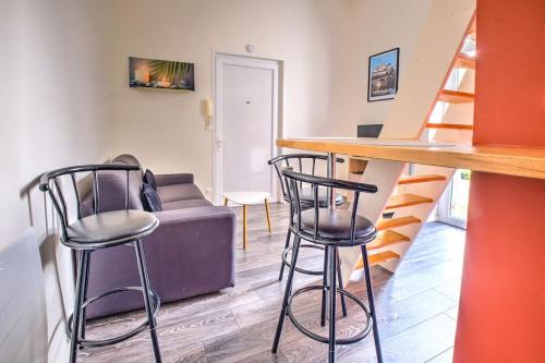 un bar avec deux chaises et un canapé dans une pièce dans l'établissement Évasion Périgourdine, à Périgueux