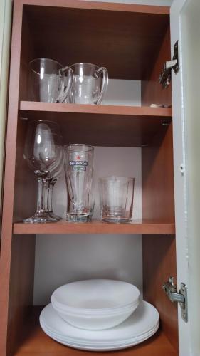 a shelf with glasses and a plate on it at Promenade Apartment in Liepāja