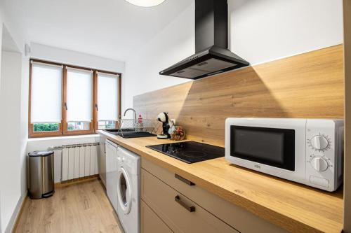 une cuisine avec un four micro-ondes sur un comptoir en bois dans l'établissement Sweet-Haven 4 Pers, Calme, Proche Autoroute, à Bousse