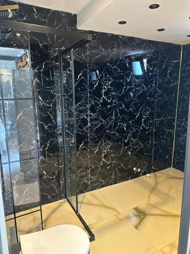 a room with a black marble wall with a white chair at Vip Otel in Istanbul
