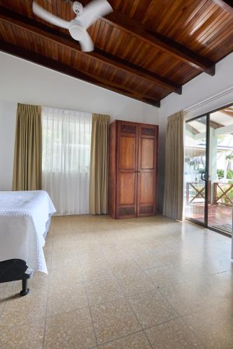 a bedroom with a bed and a ceiling fan at Perla de la Playa Beachfront Hotel in Tamarindo
