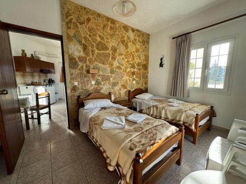 Konaki Apartments في ماليم: غرفة فندقية بسريرين ومطبخ