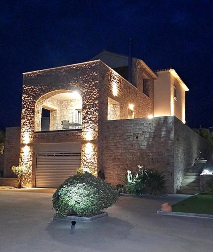 a large brick house with a garage at night at Villa Athina in Gythio