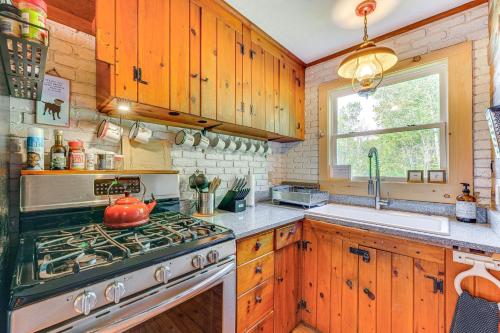 a kitchen with wooden cabinets and a stove top oven at Pet-Friendly Wilmington Retreat with Hot Tub! in Wilmington