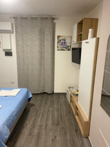 a small room with a bed and a refrigerator at La Stradina in Barletta
