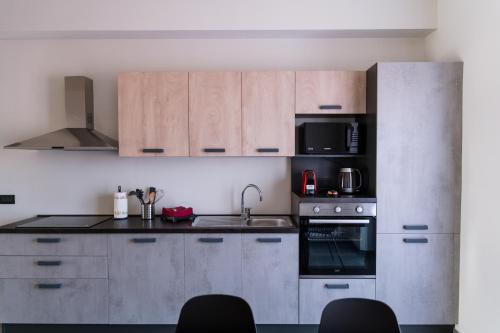 a kitchen with stainless steel appliances and wooden cabinets at IsabellApartments in Canelli