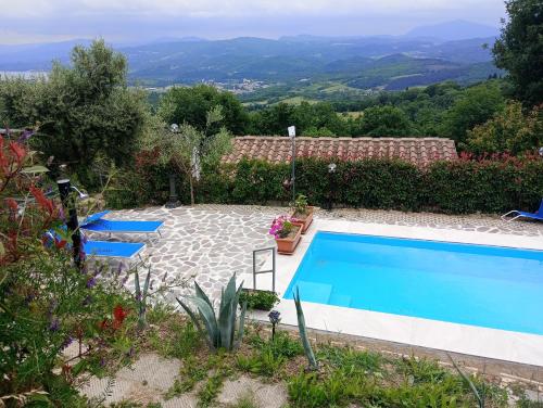 einen Pool in einem Garten mit zwei blauen Stühlen in der Unterkunft Casa di sotto in Giratola