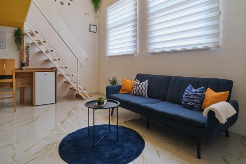 a living room with a blue couch and stairs at Apartman - Jacuzzi Spa - Tvrđava Travnik in Travnik