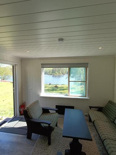 a living room with a couch and a table and a window at Gauvik - Lyngdal in Lyngdal