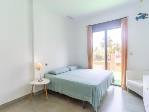 a white bedroom with a bed and a window at Spacious Holiday Home in Motril with 2 Large Terraces in Motril