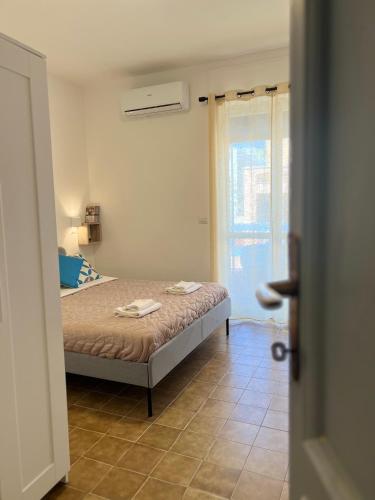 a bedroom with a bed in a room with a window at Blue Terrace Guest House in Alghero