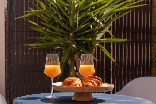 einen Tisch mit zwei Gläsern Orangensaft und Croissants in der Unterkunft COCON NOELY 1 in Toulouse