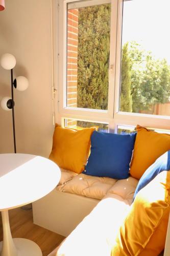 un salon avec un canapé et une fenêtre dans l'établissement T3 chaleureux à Muret, à Muret