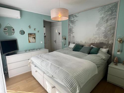 une chambre avec un grand lit et une télévision dans l'établissement Villa avec piscine privée sur la french riviera, à Saint-Laurent-du-Var