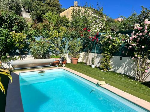 - une piscine dans un jardin fleuri dans l'établissement Villa avec piscine privée sur la french riviera, à Saint-Laurent-du-Var