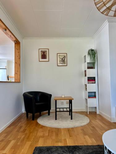 a living room with a black chair and a table at Cozy apartment in Jädraås nestled near the lake just 10 minutes from Kungsberget in Jädraås