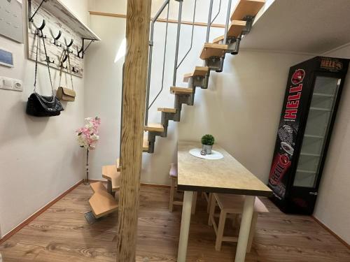 a staircase in a room with a table and a skateboard at Guszti Apartman in Pécs