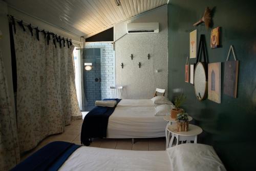 Un dormitorio con 2 camas y una mesa en una habitación en happiness house/ casa da felicidade, en Cuiabá