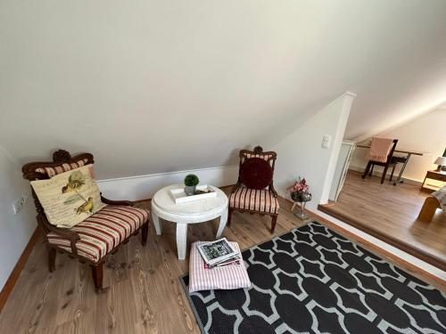 a living room with two chairs and a table at Guszti Apartman in Pécs