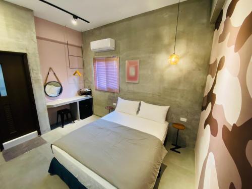 sypialnia z dużym łóżkiem i biurkiem w obiekcie Midsummer Guest House w mieście Magong