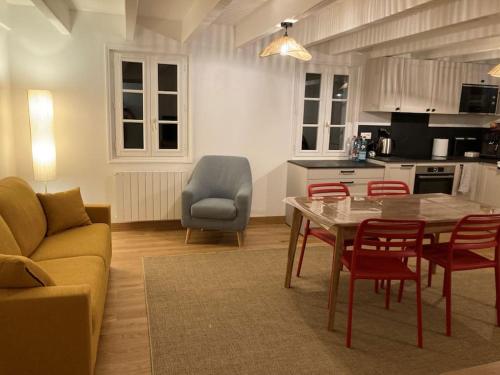 un salon avec une table et des chaises et une cuisine dans l'établissement Maison historique Sauzon, à Sauzon
