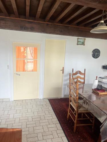a dining room with a table and a door at maison de 100 m2 comprenant 3 chambres avec jardin in Dun-sur-Grandry
