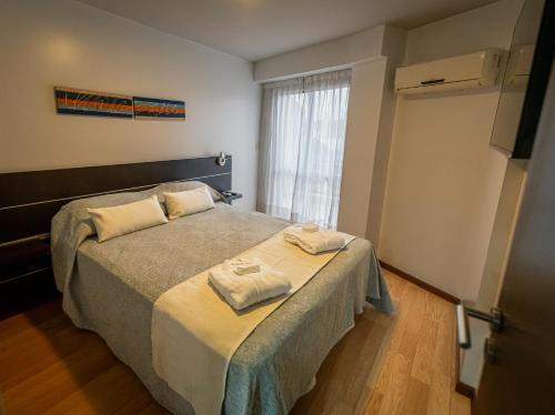 a bedroom with a bed with towels on it at Kube Apartments Express in Córdoba
