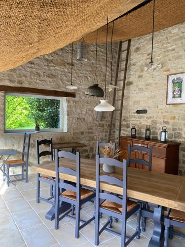 Chambres d’hôtes la bottée في Viéville-sous-les-Côtes: غرفة طعام مع طاولة وكراسي خشبية