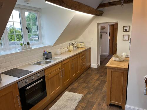 a large kitchen with wooden cabinets and a sink at Yew Tree Farm in Atherstone