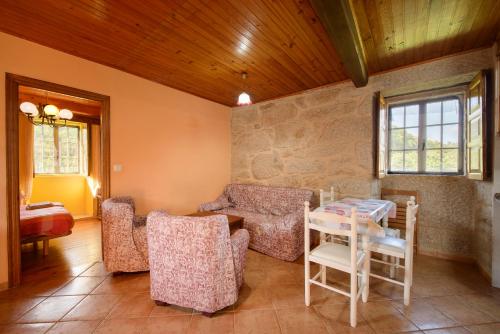 Olás de VillariñoにあるApartamentos Turísticos Casa dos Pulidosのリビングルーム(テーブル、椅子付)