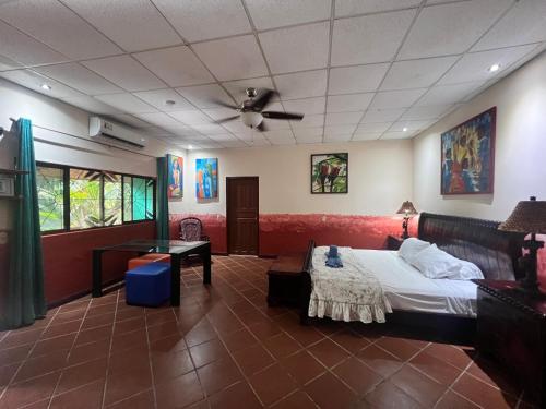 Casa Manglar Villa في بويرتو خيمينيز: غرفة نوم بسرير ومروحة سقف