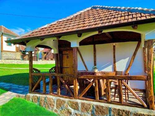 a gazebo with a table and chairs under it at Etno selo Stanojevic in Boljevac