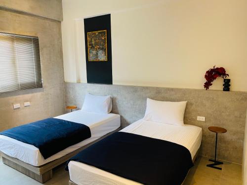 two beds sitting next to each other in a room at 夏至文旅 Midsummer Inn in Magong