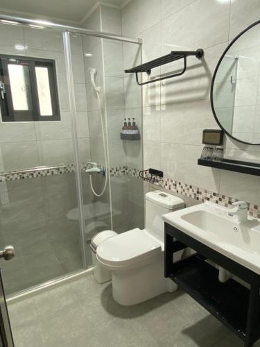 a bathroom with a toilet and a shower and a sink at 夏至文旅 Midsummer Inn in Magong