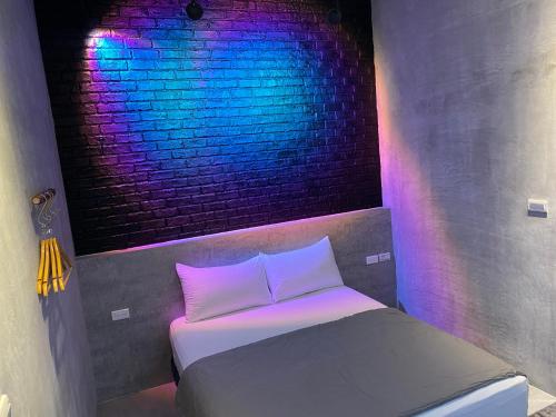 a bed in a room with a brick wall at 夏至文旅 Midsummer Inn in Magong