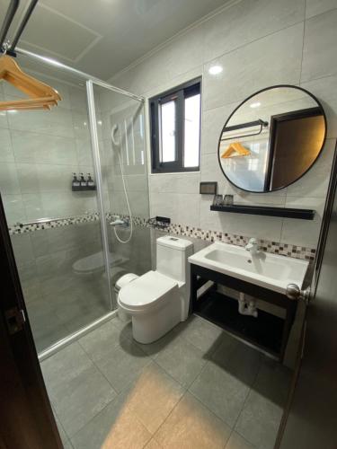 y baño con aseo, ducha y lavamanos. en 夏至文旅 Midsummer Guest House en Magong