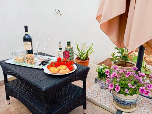 a table with a plate of food and wine glasses and flowers at La Carosa Suite in Oria