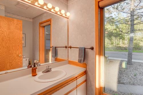 uma casa de banho com um lavatório, um espelho e uma janela em Cozy Alpine Escape Ski-InandOut at Lutsen Mtns em Lutsen