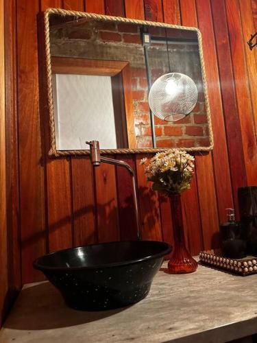 a bathroom with a black sink and a mirror at Chalé Da Pecan in Anta Gorda