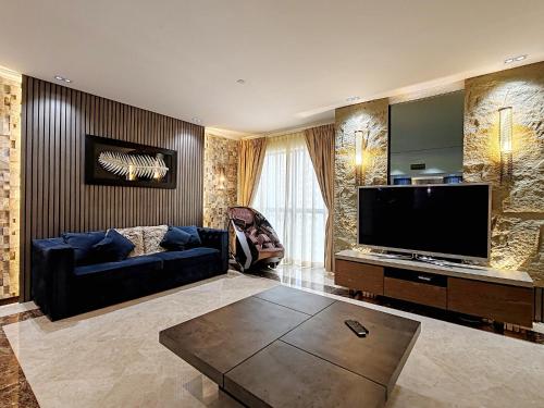 a living room with a couch and a flat screen tv at ELAN RIMAL SADAF Suites in Dubai
