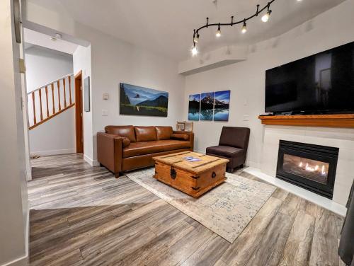 a living room with a couch and a fireplace at Updated Townhouse in Village. Pool/Hot Tub/Parking in Whistler