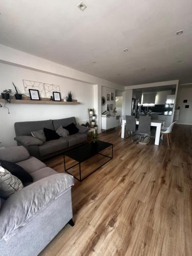 a living room with a couch and a table at Apartamento con piscina en el centro de Sanxenxo in Sanxenxo