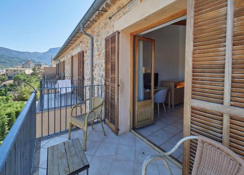 a balcony with chairs and a table and a door at Hotel Ca'l Bisbe in Sóller