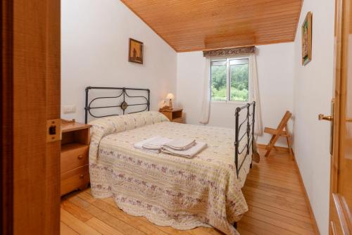 Olás de VillariñoにあるApartamentos Turísticos Casa dos Pulidosのベッドと窓のある寝室