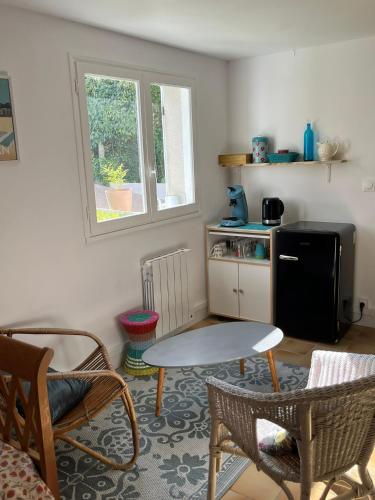 un salon avec une table et des chaises dans l'établissement Chambre cosy chez Isabelle, à Royan