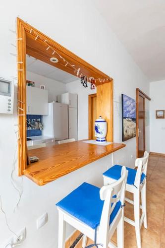 a kitchen with a counter and a table and chairs at Casa de la bruja - Haus am Meer, maximal 3 Gäste in Gáldar