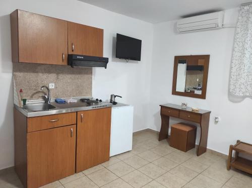 a kitchen with wooden cabinets and a sink and a desk at Vythos in Adamas