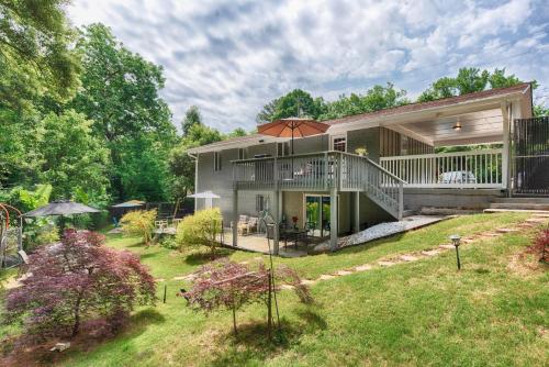 a house with a deck and a patio with an umbrella at The Creek House in Marietta