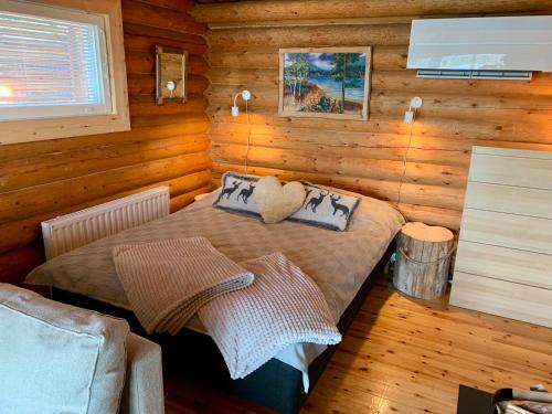 una camera con un letto in una baita di tronchi di Kaupinmaja, Ylläs - Log Cabin with Lake and Fell Scenery ad Äkäslompolo